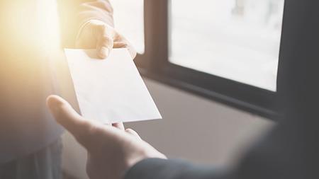 Two people exchanging an envelope