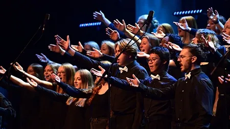 Worship choir singing and lifting their hands